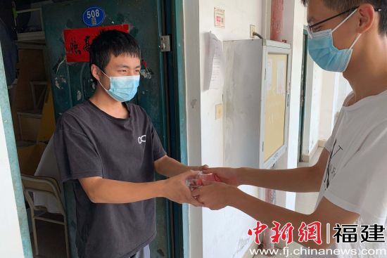 志愿者给旗山校区学生分发月饼。李录杰 摄