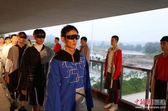 89名服装专业学生通过作品呈现了传统文化传承与创新、运动与功能结合、创意与未来等三个主题。图为服装展现场，模特走过长廊。林坚 摄