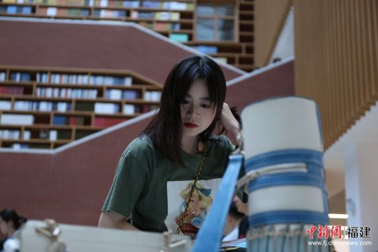 此次展出服装44个系列，鞋包、首饰45个系列，作品共300余件套。图为观众正在聚精会神地看展。林坚 摄JPG